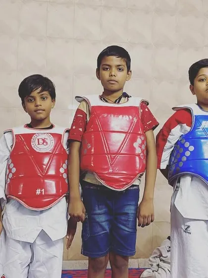 Our young fighters ready for action. Dressed in their chest guards, they are prepared to put their training to the test in a safe and controlled sparring environment.