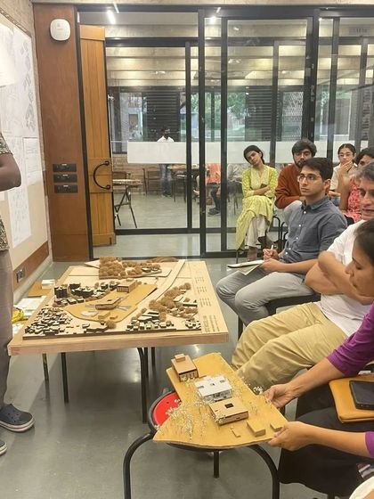 As a juror, I believe in getting hands on with the students' models. Here, I am examining a detailed site model to better understand the student's design proposal and its relationship to the context.