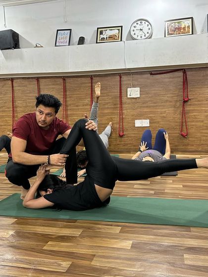Learning to adjust is a key skill for a teacher. Here, an instructor guides a student through a complex supine twist.