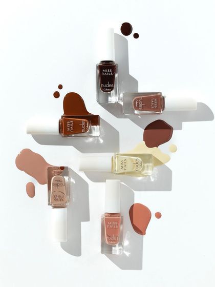 A creative explosion of nude nail polishes. We arranged the bottles in a geometric pattern and added artistic splashes of color to create a dynamic and eye-catching flatlay that showcases the entire shade range.