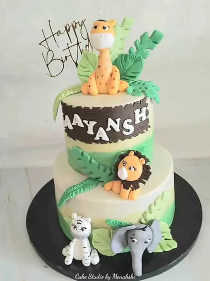 I love bringing a child's imagination to life, like with this two-tier jungle themed cake. It features adorable, hand-modelled fondant animals like a giraffe, lion, and elephant, set on a buttercream base with leafy details.