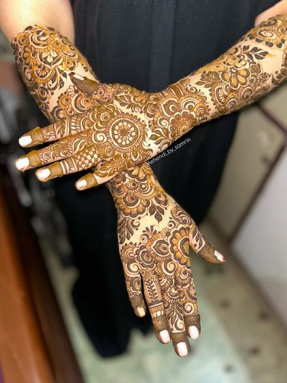 A lovely crossed-hands pose showing off the intricate floral design. This is a great option for an engagement or any pre-wedding celebration.
