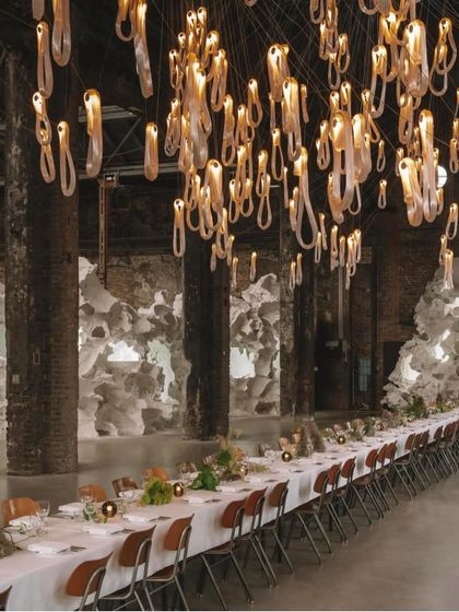A closer view of the dining table and the Bocci 87 installation, showing how the warm, pearlescent light creates an intimate and inviting ambiance.