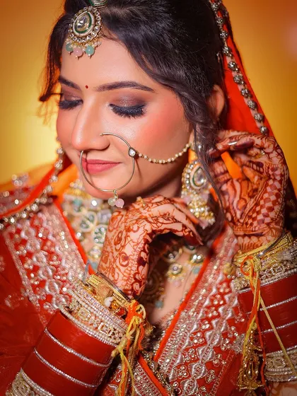 A close-up portrait of a Punjabi bride, focusing on her delicate expression and traditional jewelry.