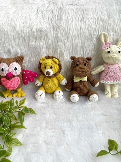 A collection of animal friends made as newborn photo props. This set includes a colorful owl, a lion, a hippo, and a bunny.