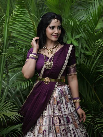 A mid-shot of the model, focusing on her confident pose and the detailed craftsmanship of her jewelry and outfit.