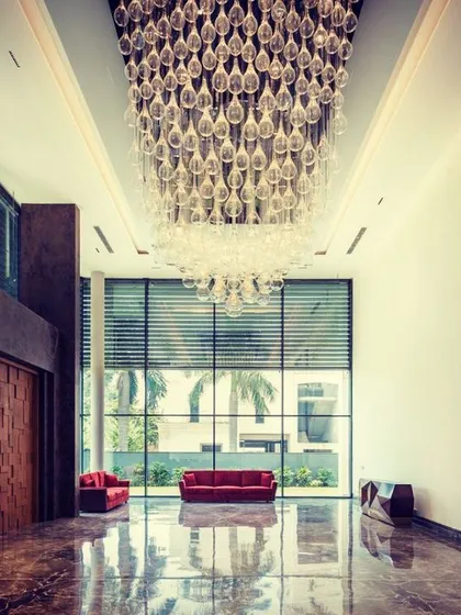 Chandeliers are the jewellery of architecture, and this double-height space required a magnificent piece. This massive, cascading crystal fixture fills the vertical volume, creating a spectacular statement of luxury and artistry that is visible from multiple levels of the home.
