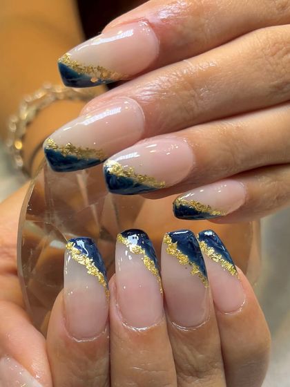 A close-up of the blue and gold foil design, highlighting the texture and shine of the gold leaf against the dark, glossy blue.