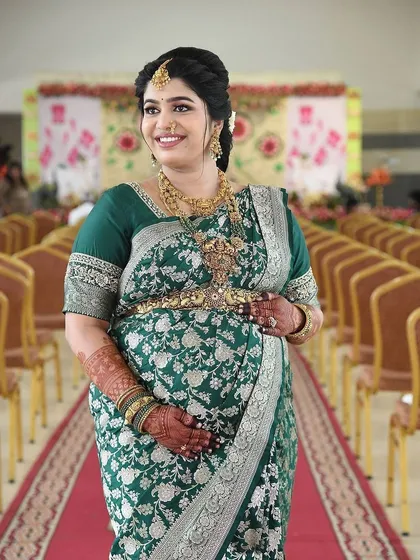 A beautiful mom-to-be at her Seemantha ceremony. The rich, dark stain of her mehendi stands out against her gorgeous green saree, completing her traditional look.