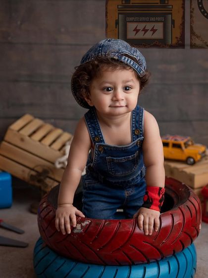 Getting ready to work! This candid shot captures a moment of exploration during our little mechanic themed shoot. The setup includes toy tools, a mini car, and a garage-style backdrop for a complete look.