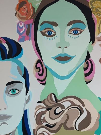 A close-up of the hospital mural, showing the vibrant faces and expressive features designed to bring joy and comfort to the space.