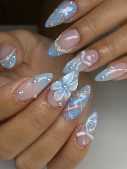 A fairytale on your fingertips. This intricate nail art set on long stiletto extensions features a soft blue and pink ombré base, delicate 3D bows, plaid patterns, and pearl embellishments for a truly magical look.