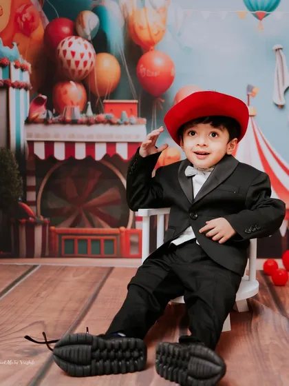 Dressed up and ready to celebrate. His little suit and oversized shoes add a touch of playful charm to his carnival-themed photos.