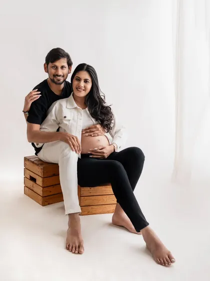 A relaxed and happy couple's portrait. Their casual black and white outfits give this studio shot a modern and timeless feel. The wooden crates add a nice rustic touch.