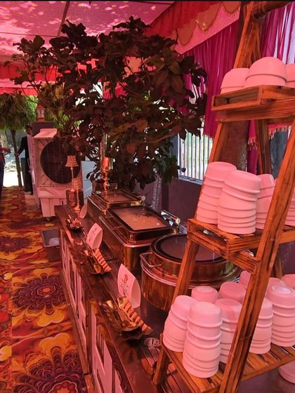 Our buffet line at a daytime party, featuring a rustic wooden ladder for stacking bowls. This creative presentation detail adds a unique touch to the overall decor.