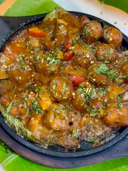 The Hot Sizzling Bonda being served fresh from the sizzler plate. The steam rising from the dish promises a hot and flavourful experience, combining South Indian tradition with a fiery kick.