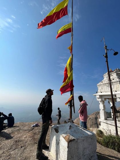 At the summit of Savandurga, next to the Nandi temple and the fluttering Kannada flags, a truly iconic Karnataka trekking moment.