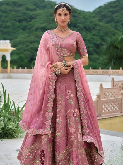 A full-length portrait in the dusty rose lehenga, highlighting the beautiful drape of the dupatta and the detailed handwork.