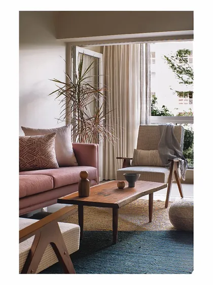 We believe in creating spaces that flow seamlessly. This living area uses a warm, earthy palette with a dusty rose sofa and natural wood furniture. The layout is thoughtfully planned to feel cozy and elegant, proving that even in a compact Mumbai apartment, you can create a soothing and comfortable home.