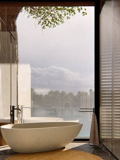 A rendering of a bathroom for the Atlanta wellness home, featuring a freestanding tub with a panoramic view of the lake. The design uses fluted glass and natural materials to create a serene, spa-like retreat.