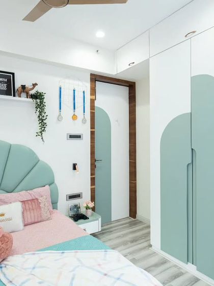 This shot captures the entire room, from the bed to the study area and the arched doorway, all tied together with a consistent color scheme and design language.