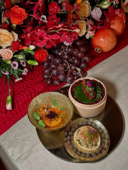 A trio of appetizers from a multi-course dinner, featuring Jiang's chicken, an Asian prawn and crab ceviche tostada, and a delectable bite served in a mini bamboo steamer.