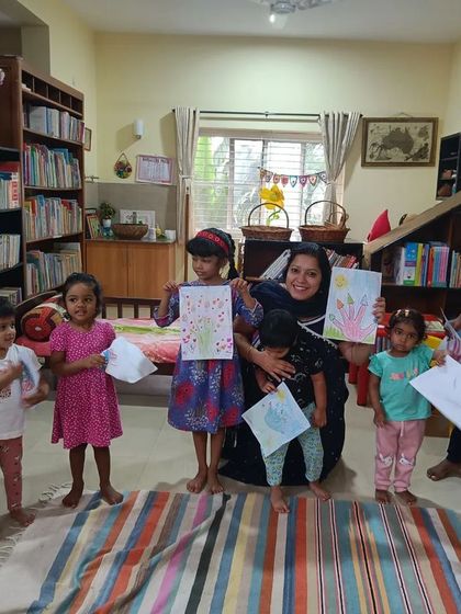 The storyteller gathers with the children to admire their drawings from the "Bondapalli" story.
