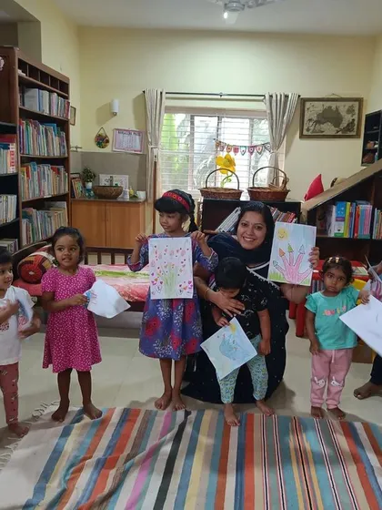 A duplicate shot capturing the happy smiles of the children with their artwork.