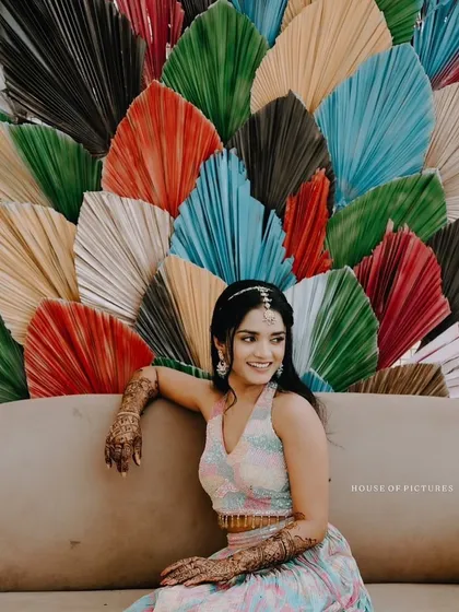 A modern and vibrant photo booth backdrop created with large, multi-colored dried palm leaves. This unique and artistic setup provides a fun and memorable spot for guests to take pictures.