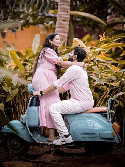 A fun and playful moment on a vintage blue scooter, set against the tropical plants of our garden.
