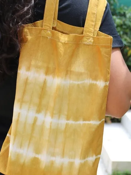 A participant's finished tote bag, dyed with marigold petals to create a lovely yellow striped pattern.
