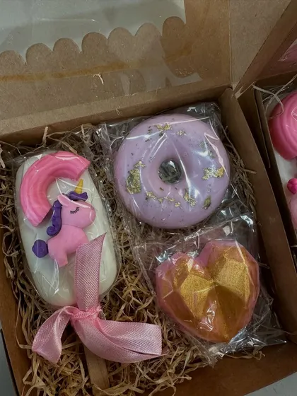 A luxurious unicorn-themed gift box with a unicorn popsicle soap, a gold-dusted heart soap, and a lavender donut soap.