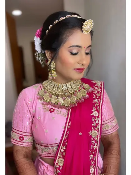 Another angle of this pretty-in-pink bridal look. The updo is decorated with fresh flowers, adding a soft and romantic touch to the overall style.
