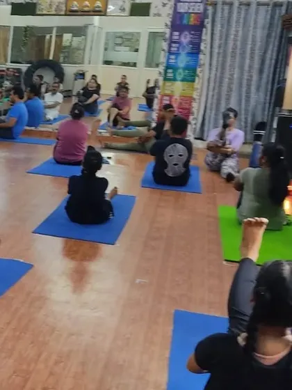 A wide shot of our studio during a class, showing students engaged in various stretches. We offer a spacious and well-equipped environment for your practice.