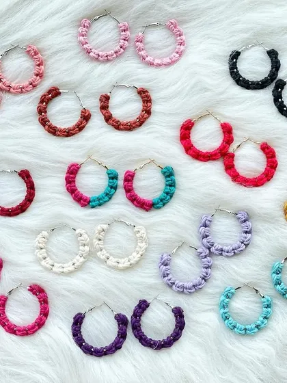My collection of macrame hoop earrings, available in a wide spectrum of colors. This image displays pairs in shades of pink, red, black, yellow, purple, and blue, showing how these lightweight knotted hoops can add a simple yet colorful statement to your look.