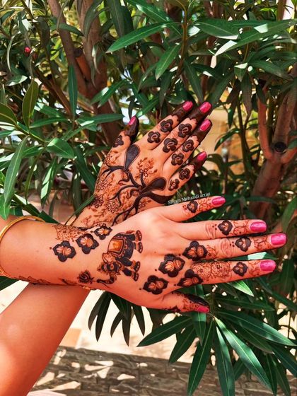 The same design shown against a natural green background, highlighting the dark, rich stain of the henna.
