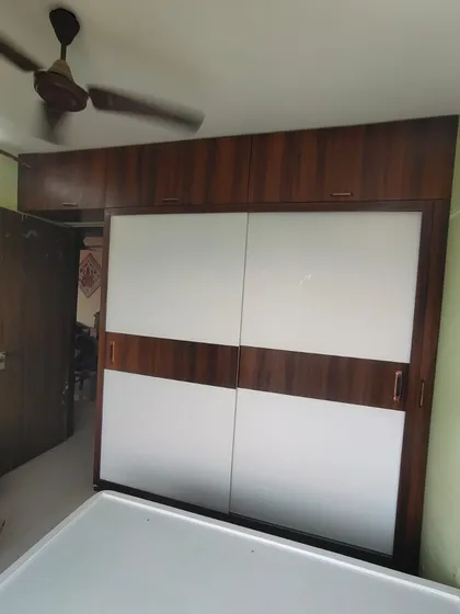 A two-door sliding wardrobe with a classic white and wood-grain combination, a timeless design that fits many decor styles.