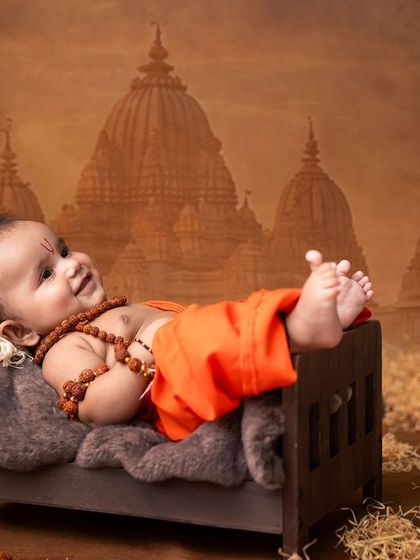 Even the youngest can be a part of our divine themes. This joyful three-month-old baby boy makes an adorable Lord Rama, captured against a backdrop of ancient temples.