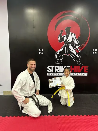 Another proud moment as a young girl receives her yellow belt. Our coaches are dedicated to mentoring the next generation of martial artists.