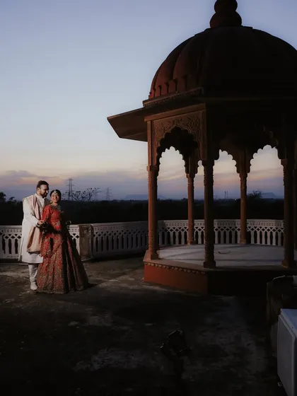 A wider angle of the couple at Umaid Palace, showing the grandeur of the location as they stand together, ready to face the world.