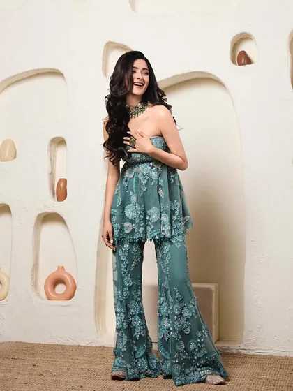 I love creating modern silhouettes like this. Here, a strapless, floral-embroidered peplum top is paired with matching flared pants, offering a chic and contemporary alternative to a traditional lehenga for a sangeet or cocktail event.