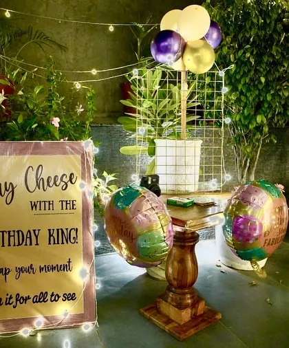 A fun, interactive element for a birthday party. This "Say Cheese with the Birthday King" sign encourages guests to take photos and be part of the memories.