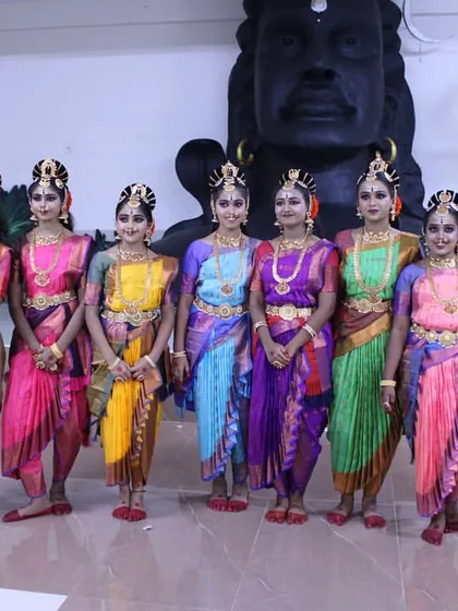 My talented troupe of dancers in their beautiful costumes for the 'Nava Durga' production, posing in front of a magnificent Shiva statue.