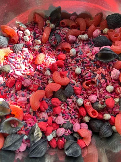 A close-up of the beautiful, non-toxic filler from our Valentine's sensory kit. We hand-dye rice, chana, and pasta in vibrant colors to create an irresistible texture for little hands to explore.