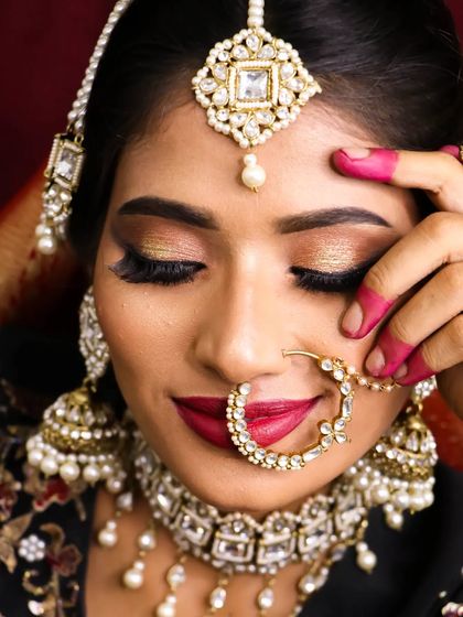 A soft bridal glam look with golden glitter eyes and a bold red lip. This close-up shows the beautiful texture of the eyeshadow and the precision of the lip application.