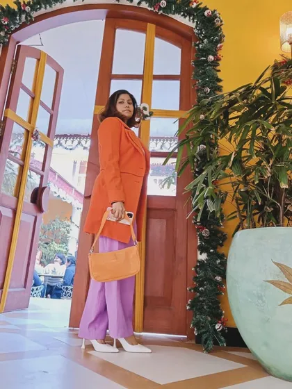 I love playing with unexpected color combinations to create a look that pops. This outfit pairs a vibrant orange coat with lavender trousers, proving that bold color blocking can be incredibly chic and full of personality.