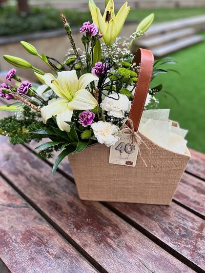 A full view of the masculine 40th birthday floral arrangement, showcasing the handsome jute container with a leather-style handle.