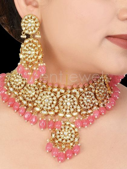 A magnificent Kundan choker with pink beads and matching oversized earrings. This set is filled with grace and charm, perfect for the bride or her bridesmaids.
