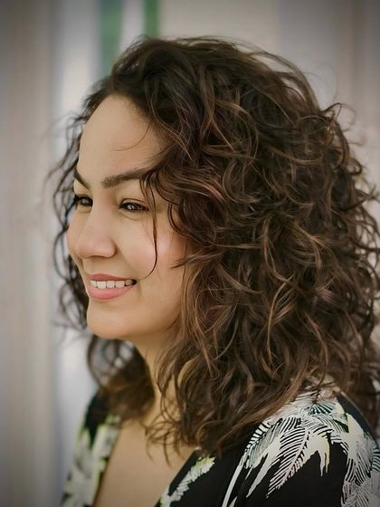 A profile shot that captures the soft, touchable texture of these natural curls.