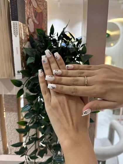 The square nail shape provides a perfect canvas for this minimalist and chic botanical nail art.